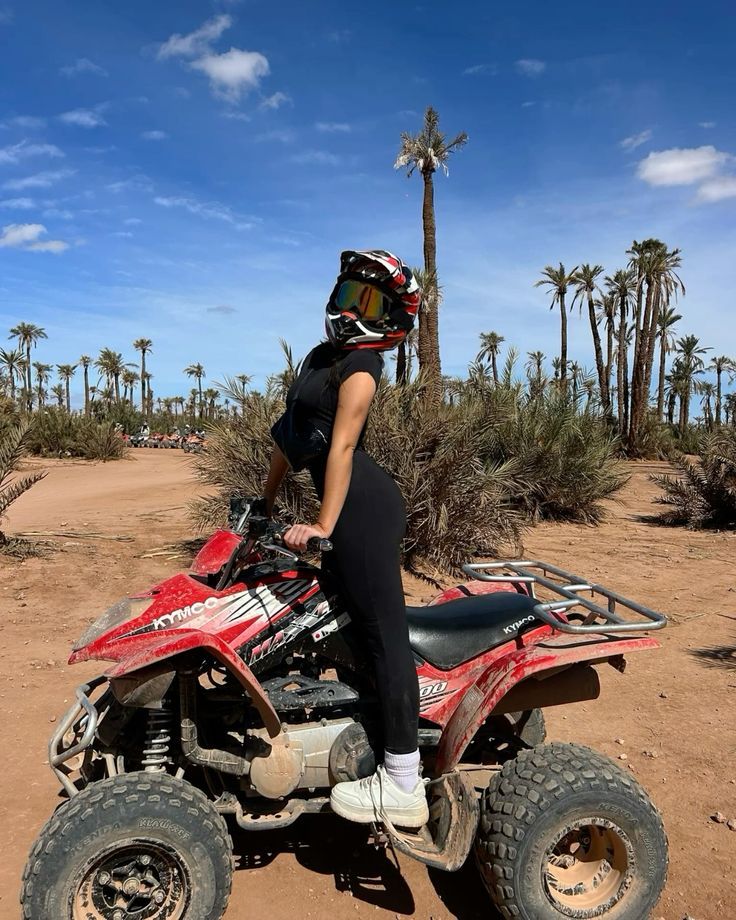 Rider on a red quad in the palm grove