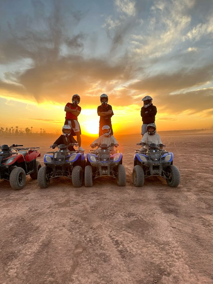 Group of quad riders posing at sunset